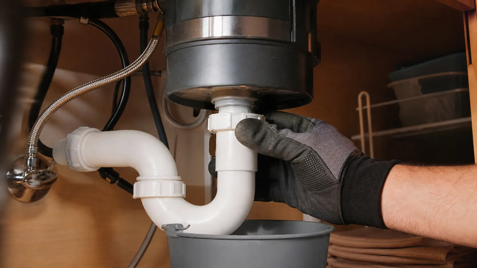 Checking the P-trap under a garbage disposal for a clog.
