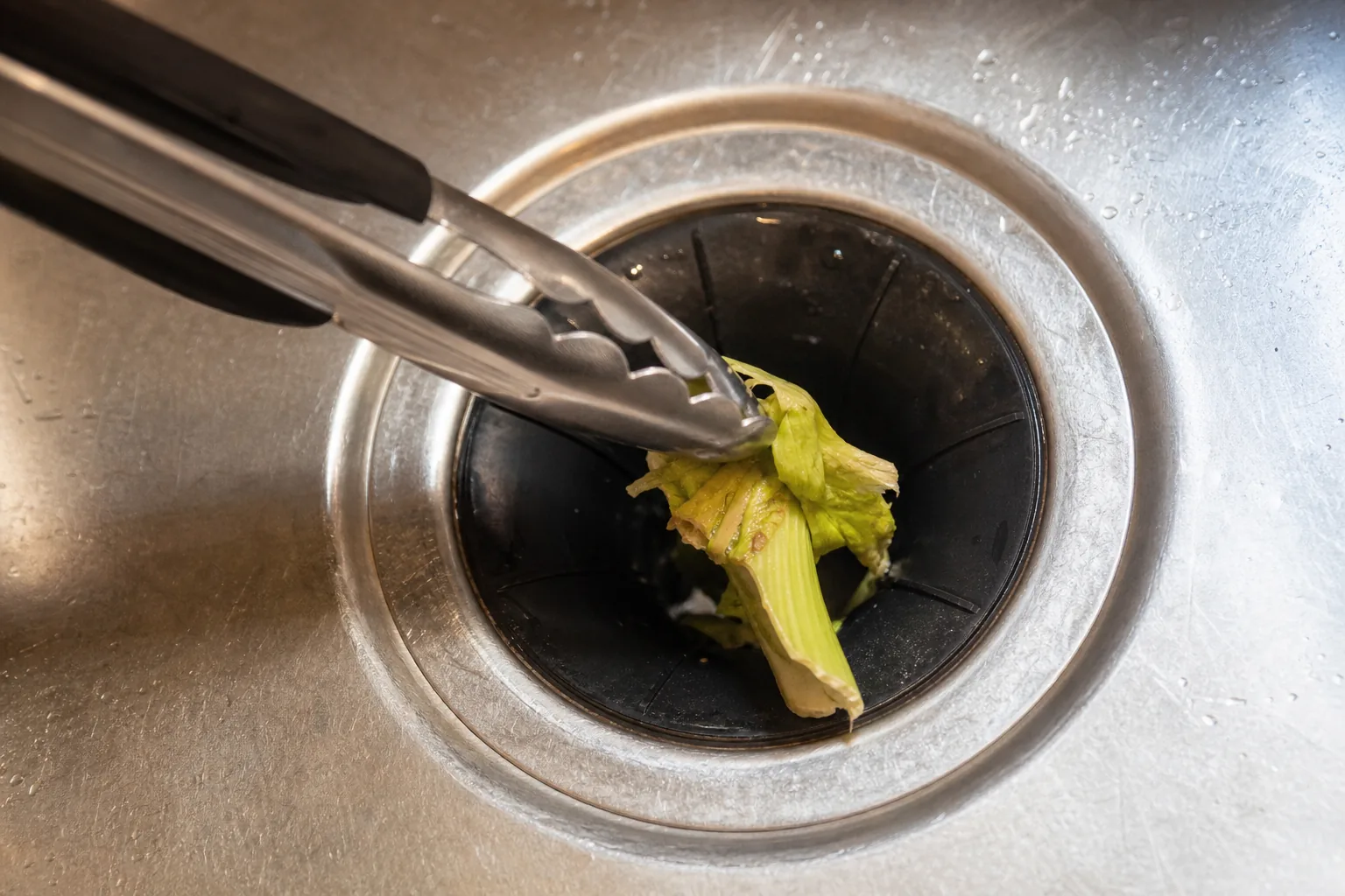 Removing a fibrous food scrap that jammed a garbage disposal.